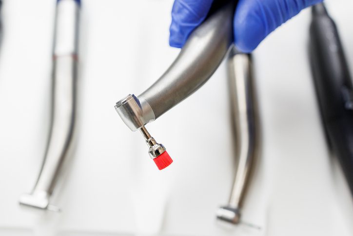 Dental drill held by gloved hand