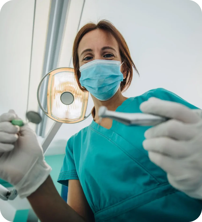 Dentist holding tools and wearing mask