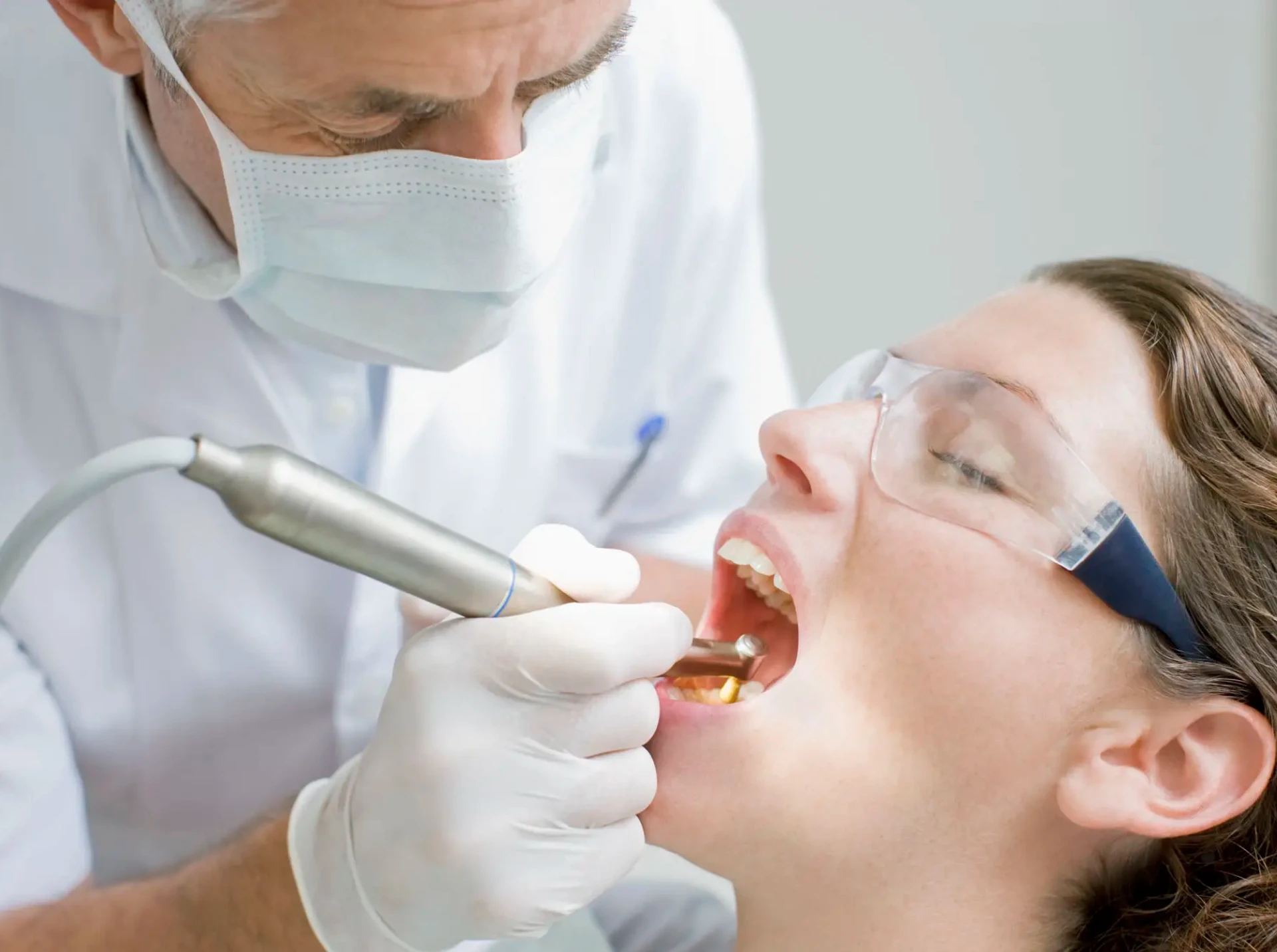 Dentist using drill on patient's teeth